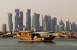 Tradisjonelle båtar og moderne høghus i Doha i Qatar