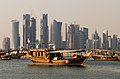 Tradisjonelle båtar og moderne høghus i Doha i Qatar